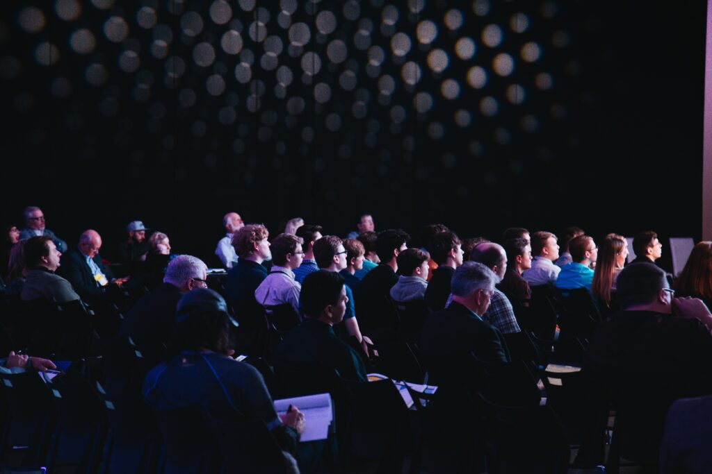 Attendees engrossed in taking notes at an event conference: An event marketing example
